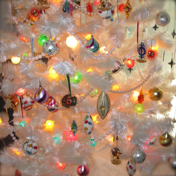 Our "Mod" fiberglass tree was reworked with late 60's plastic diamonds and starbursts as well as vintage modern Resl Lenz glass and foil ornaments . 1950's aluminum icicles add sparkle and some "spinners" float above the GE Lighted Ice bulbs.